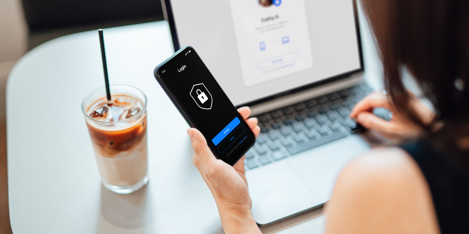 Young Business Woman Logging in Online Security System On Laptop With Mobile App On Smartphone